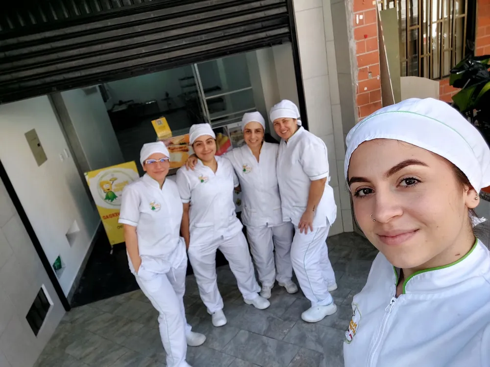 Equipo de trabajo frente a la fábrica de arepas